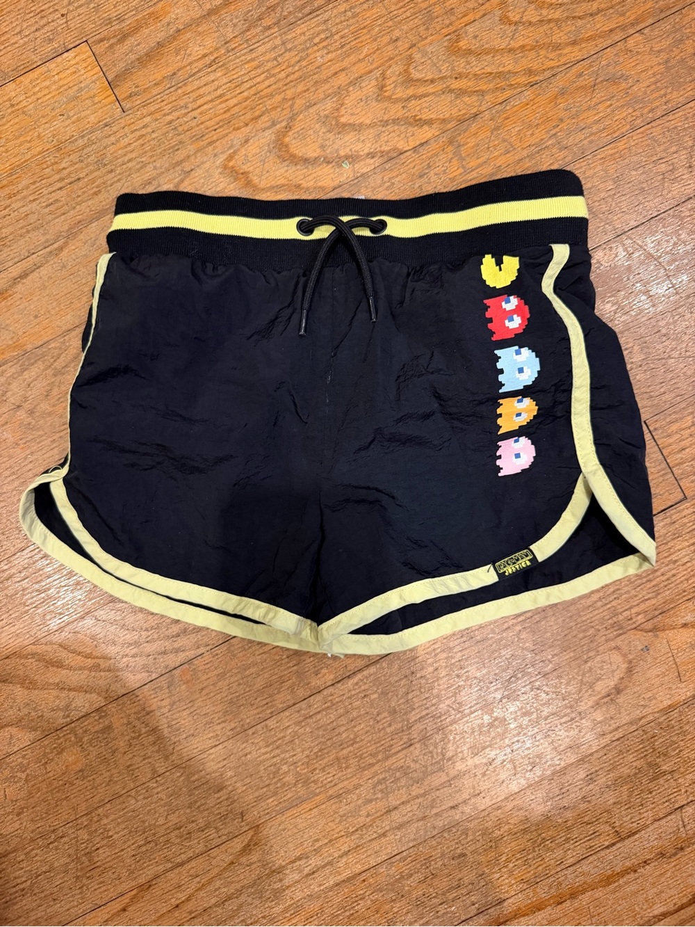 Justice Black Athletic Shorts with Yellow Trim and Retro Pixel Art